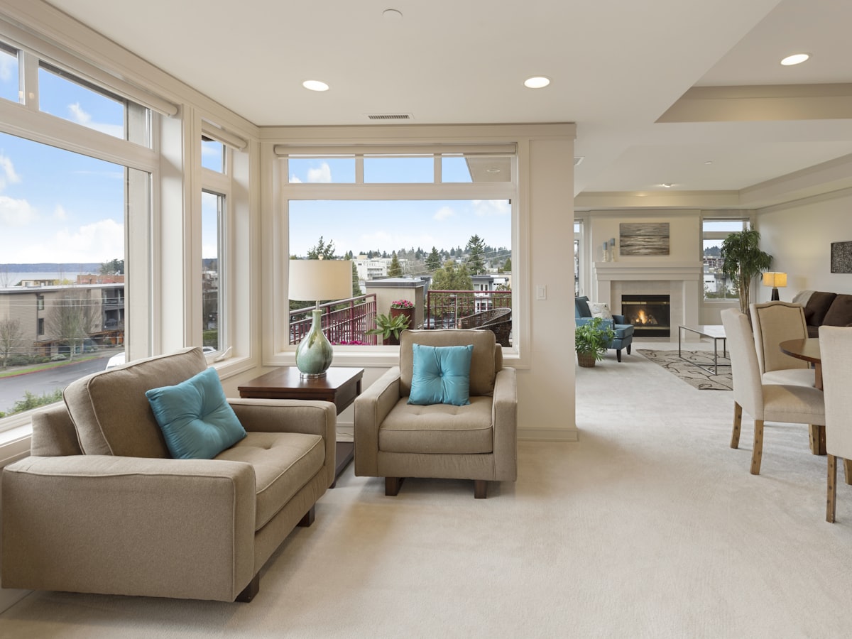 Sunlit living room in a rental property overlooking a residential neighborhood