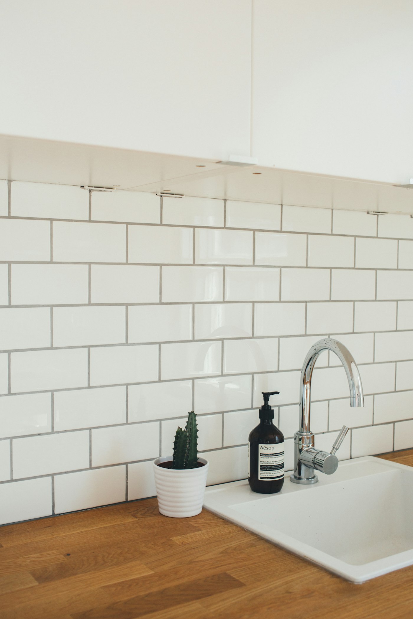 Newly renovated kitchen with white subway tile and butcher-block counters