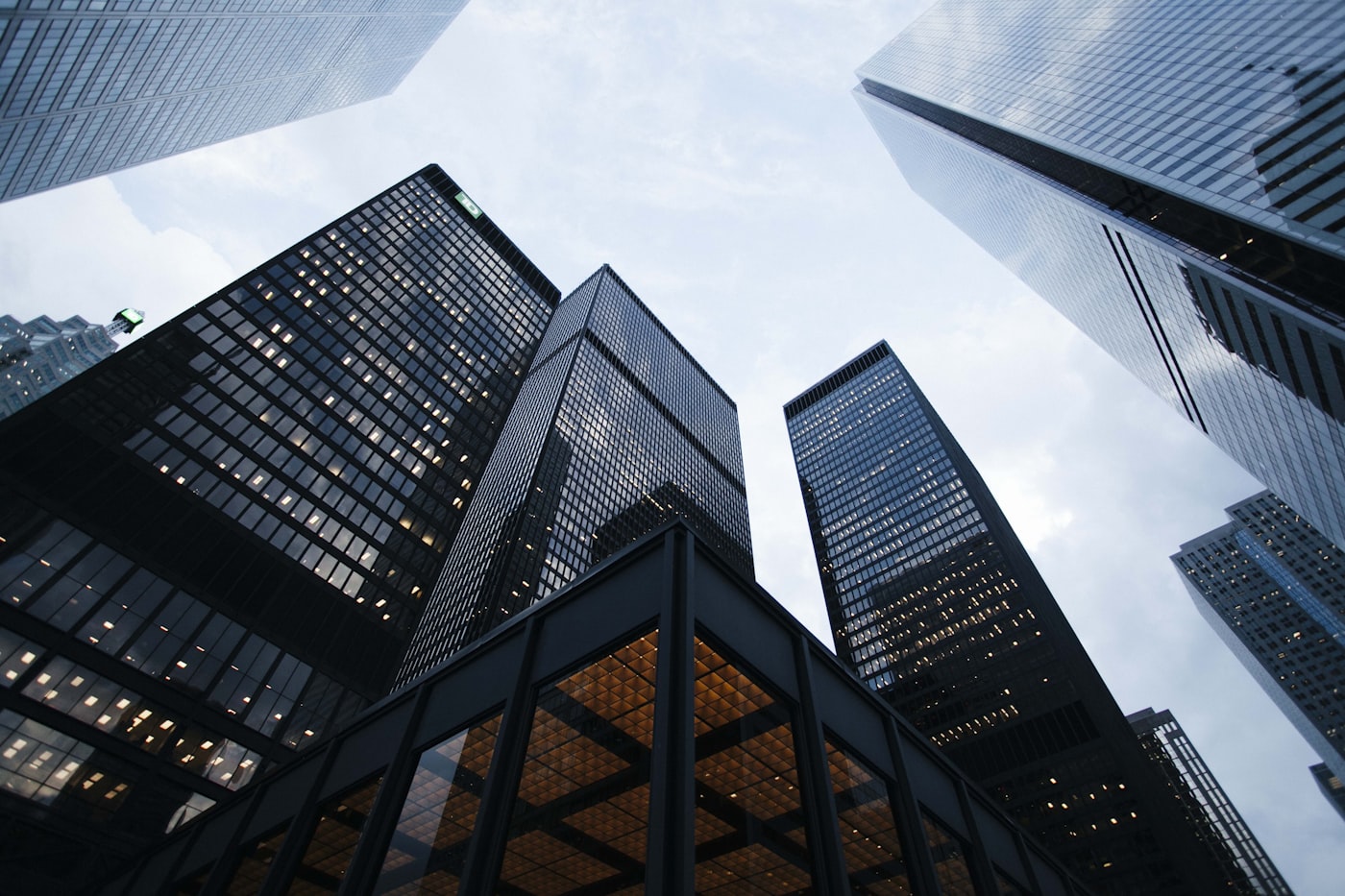 Looking up at glass office towers against a bright sky